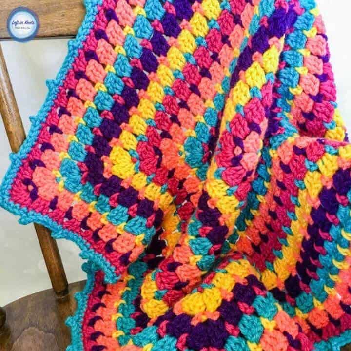 A colorful crochet baby blanket made with the block stitch