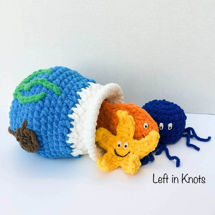 A crochet fish bowl toy with a goldfish, jellyfish and starfish