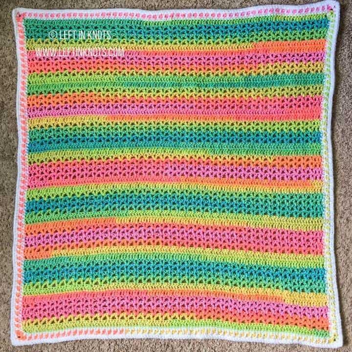 A bright neon rainbow crochet baby blanket