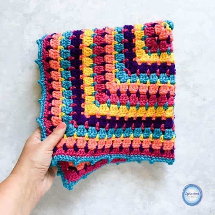 A colorful crochet baby blanket made with the block stitch