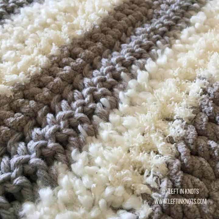 A crochet rug made with differently textured yarn