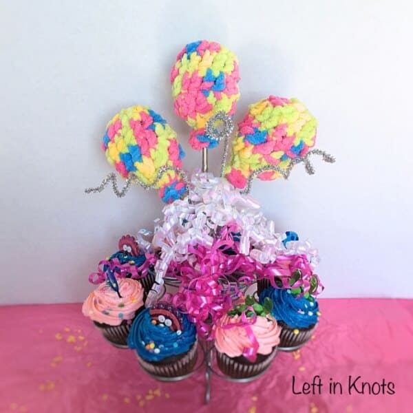 Crochet party favor water balloons displayed with cupcakes