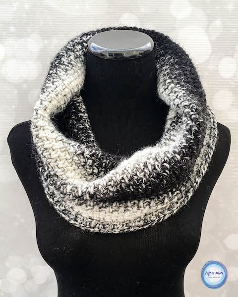 A black and white crochet cowl made with the moss stitch