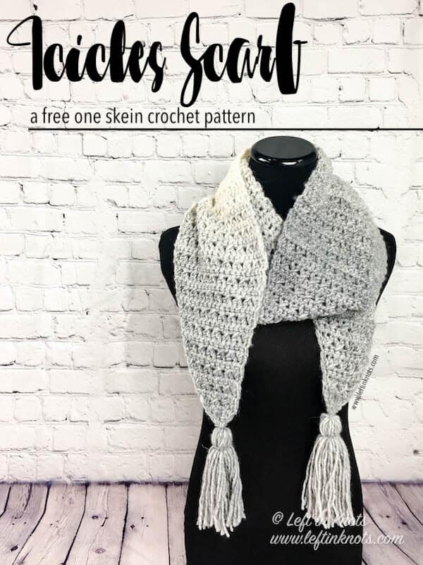 A gray and cream scarf with angled edges and tassels