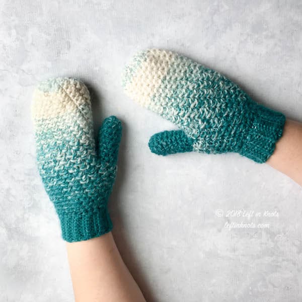 Teal and cream crochet mittens made with the lemon peel stitch