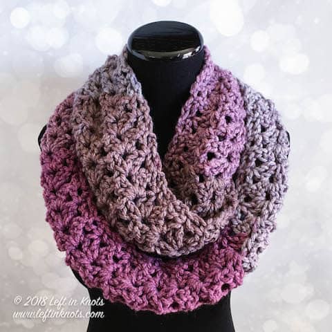 A purple chunky crochet infinity scarf made with the iris stitch