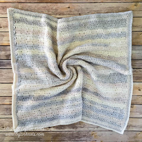 A gender neutral baby blanket made with self striping yarn