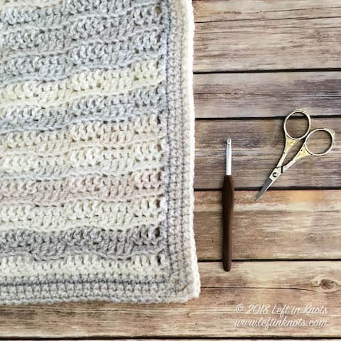 A gender neutral baby blanket made with self striping yarn