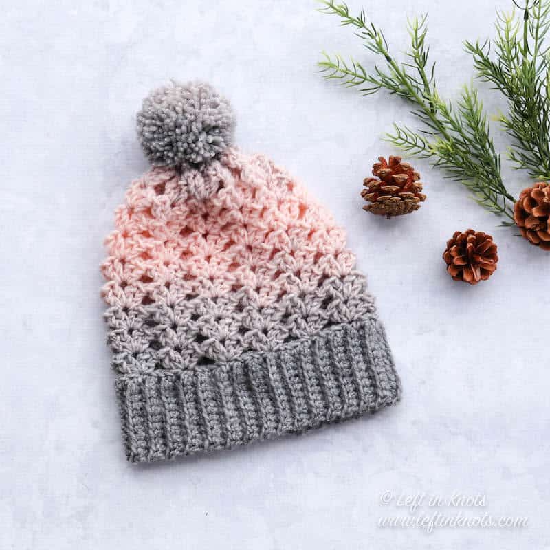 A pink and gray crochet beanie made with the iris stitch