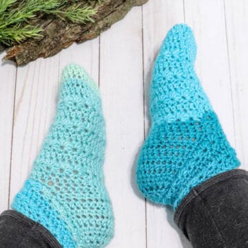 A pair of crochet slipper socks made with Caron Cakes yarn and the star stitch