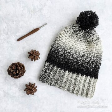 A black and white crochet beanie made with the moss stitch