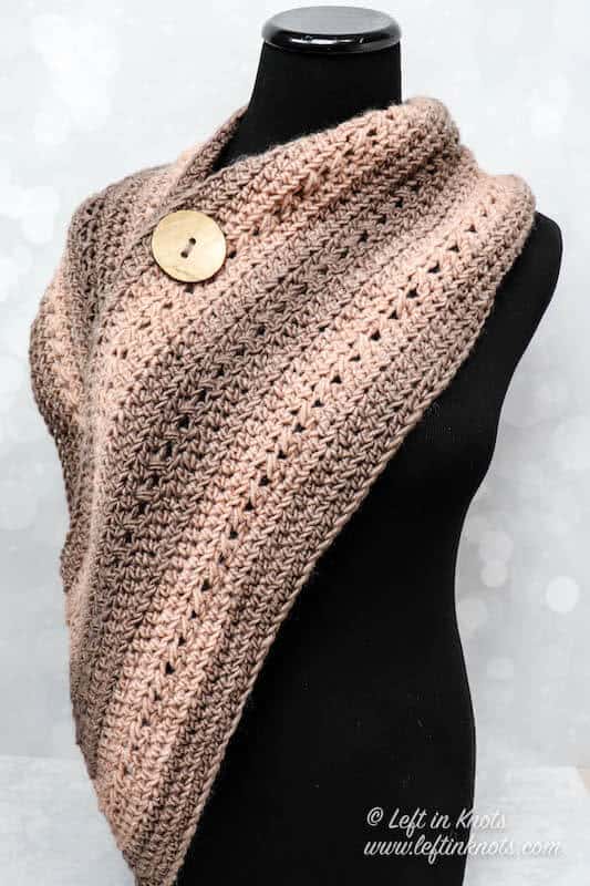 A wide crochet wrap scarf with button
