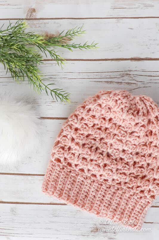 A blush colored crochet beanie made with chainette yarn