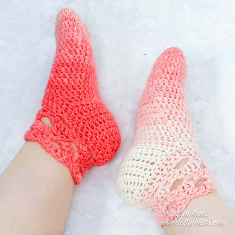 A pair of coral and cream crochet slipper socks made with the arcade stitch