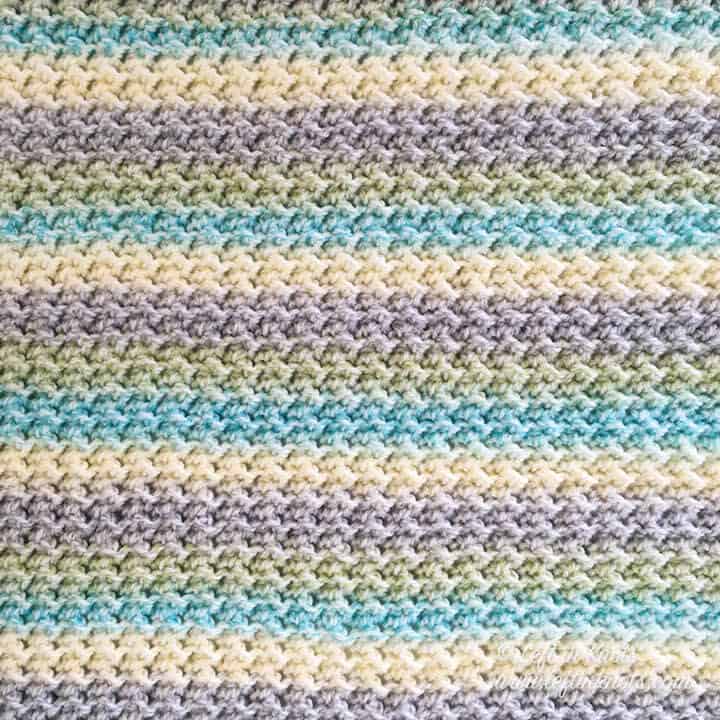 A self striping crochet baby blanket made with the crunch stitch and fuzzy border