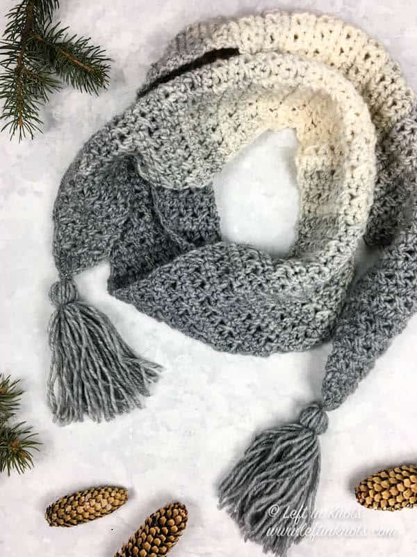 A gray and cream scarf with angled edges and tassels