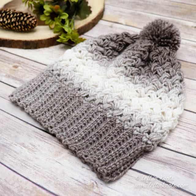 A taupe and cream crochet beanie made with the bean stitch