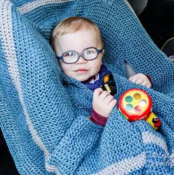 A hooded crochet car seat blanket for toddlers