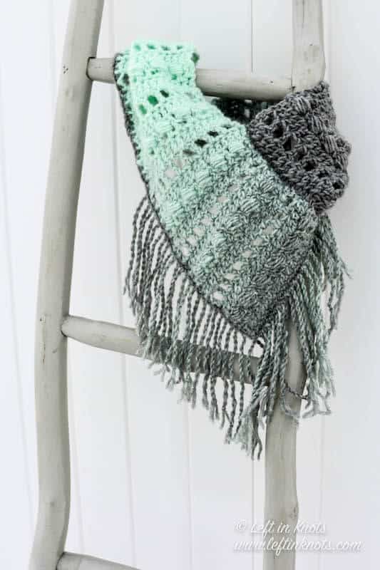 A gray and mint bandana style crochet cowl with fringe