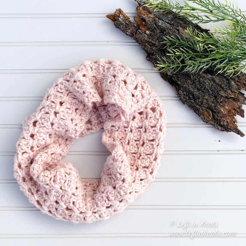 A blush crochet cowl made with chainette yarn