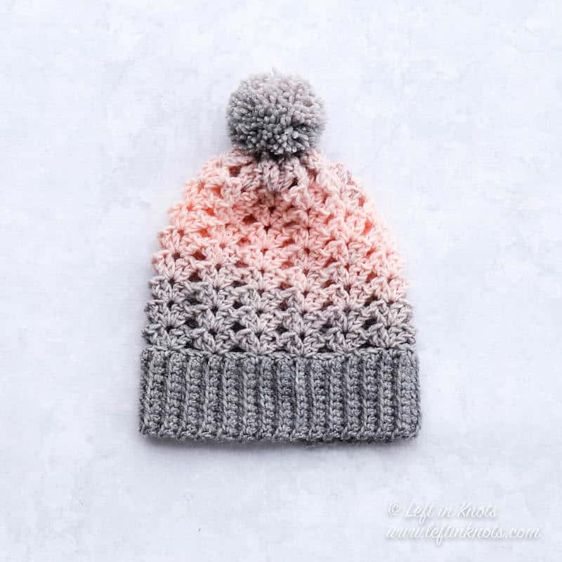 A pink and gray crochet beanie made with the iris stitch