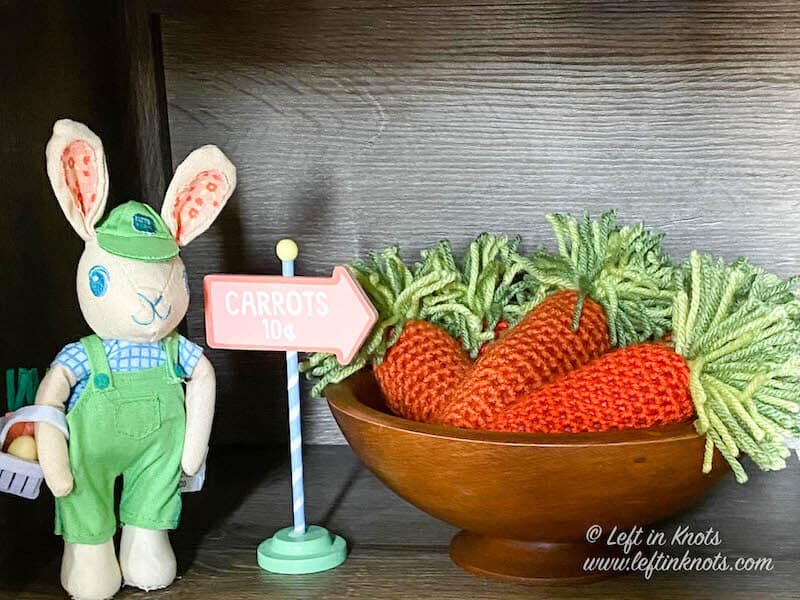 Crochet carrots in a bowl next to an Easter Bunny