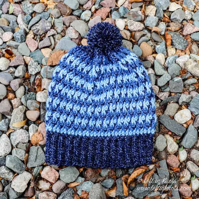 A denim blue crochet beanie made with the alpine stitch