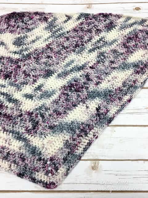 A striped crochet shawl made with two skeins of hand dyed yarn