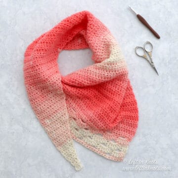 A coral and cream asymmetrical crochet scarf using the arcade stitch