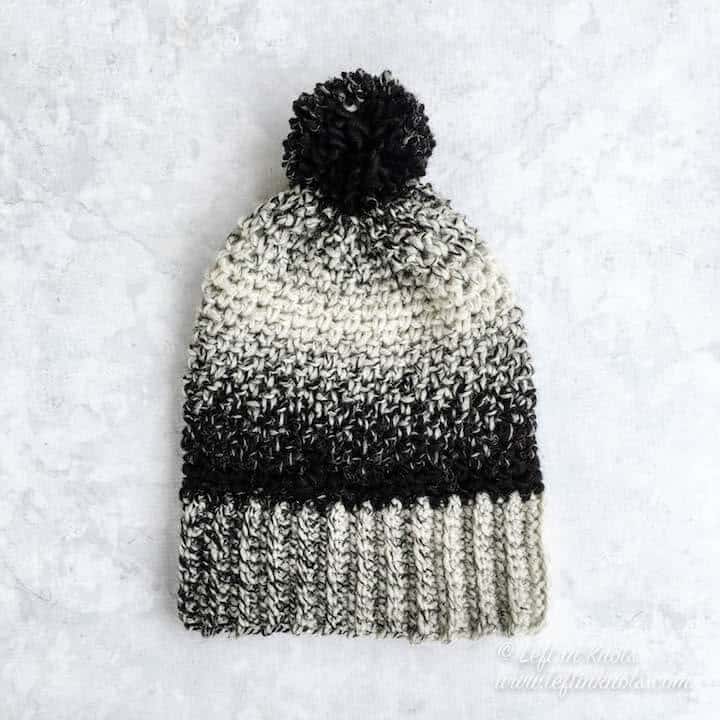 A black and white crochet beanie made with the moss stitch