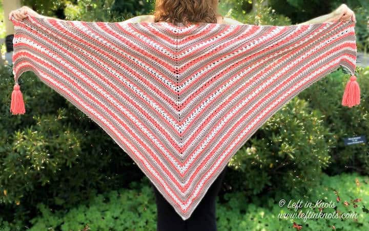 A crochet shawl made with textured stitches and tassels