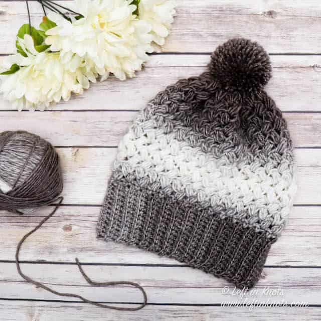 A taupe and cream crochet beanie made with the bean stitch