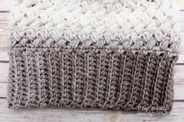 A taupe and cream crochet beanie made with the bean stitch