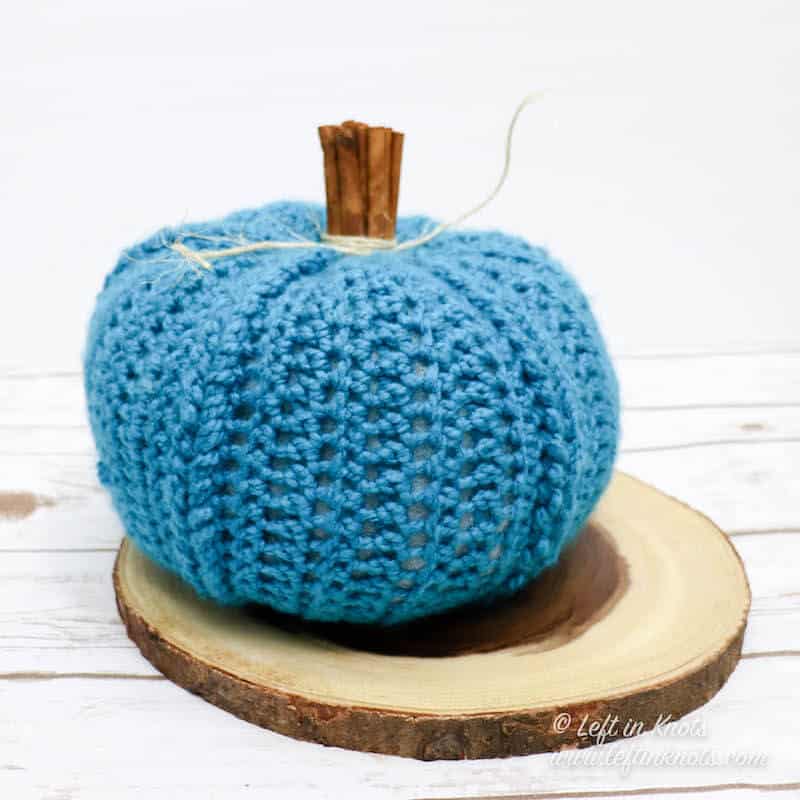A crochet pumpkin with cinnamon stick stem