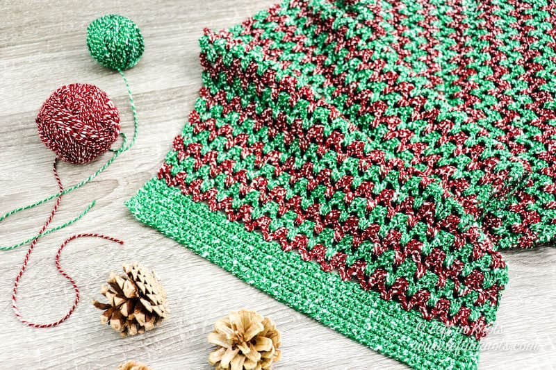 A red and green crochet Christmas table runner