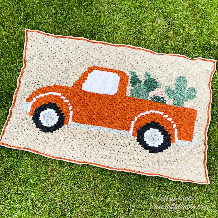 A crochet blanket of a vintage truck and plants