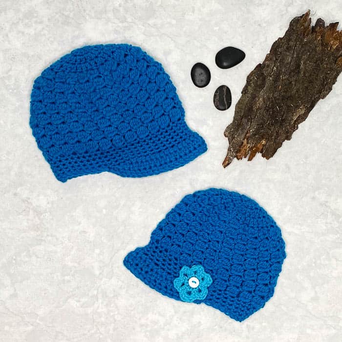 Blue crochet beanie with a small brim and flower accent